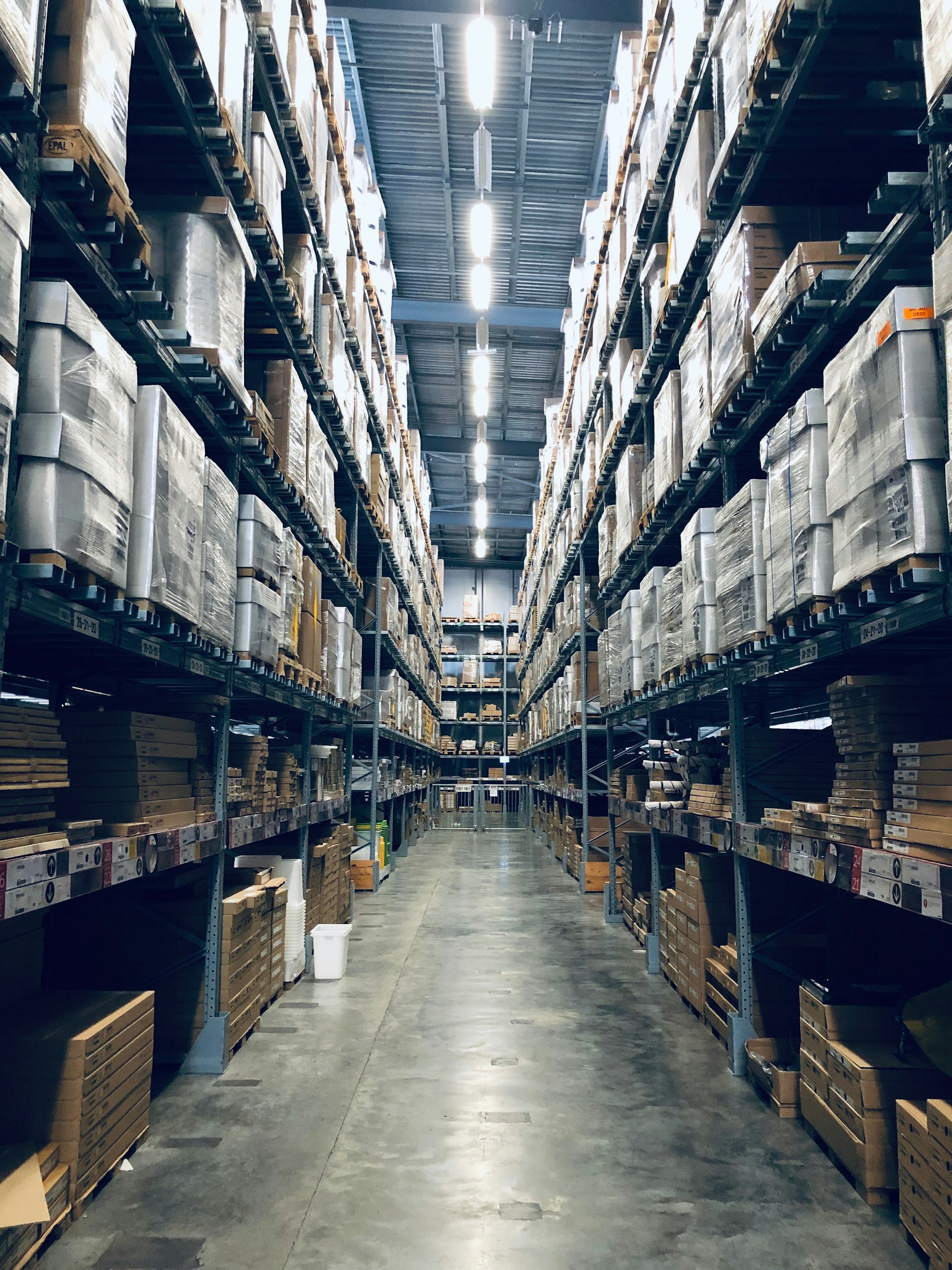 Anaqueles de bodega con cajas de mercancía organizadas, representando el inventario de mayoreo de Cameestrella